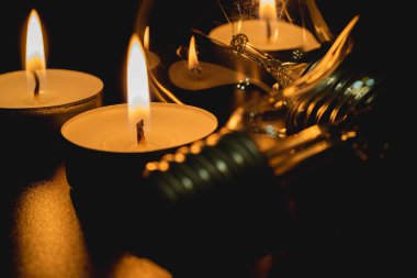 Arka planda elektrik lambası ve mum var. Parlayan lamba ve mum. Elektrik kesintisi yok. Yüksek elektrik fiyatları. Elektrik tasarrufu.