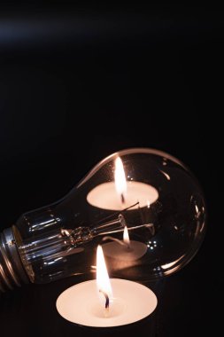 Arka planda elektrik lambası ve mum var. Parlayan lamba ve mum. Elektrik kesintisi yok. Yüksek elektrik fiyatları. Elektrik tasarrufu.