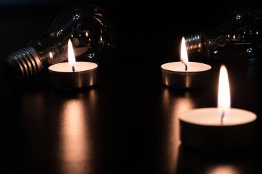Arka planda elektrik lambası ve mum var. Parlayan lamba ve mum. Elektrik kesintisi yok. Yüksek elektrik fiyatları. Elektrik tasarrufu.