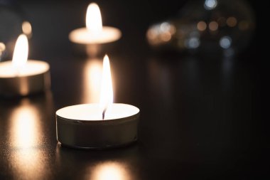 Arka planda elektrik lambası ve mum var. Parlayan lamba ve mum. Elektrik kesintisi yok. Yüksek elektrik fiyatları. Elektrik tasarrufu.