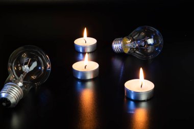 Arka planda elektrik lambası ve mum var. Parlayan lamba ve mum. Elektrik kesintisi yok. Yüksek elektrik fiyatları. Elektrik tasarrufu.