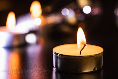 yanan mum. Mavi karanlıkta mumlar ve kutsal anlar için altın bokeh. Siyah arka planda süzülen mumlar