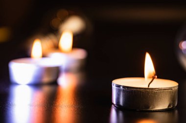 yanan mum. Mavi karanlıkta mumlar ve kutsal anlar için altın bokeh. Siyah arka planda süzülen mumlar