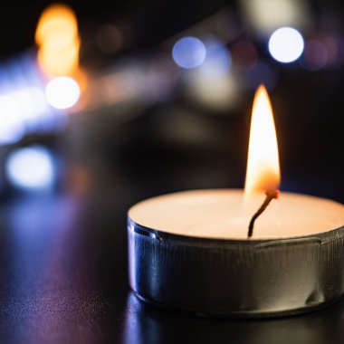 yanan mum. Mavi karanlıkta mumlar ve kutsal anlar için altın bokeh. Siyah arka planda süzülen mumlar