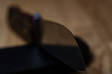 Siyah arka planda el yapımı avcı bıçağı. Deri kınalı el yapımı. Yüksek karbonlu çelik.