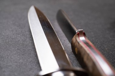 Siyah arka planda el yapımı avcı bıçağı. Deri kınalı el yapımı. Yüksek karbonlu çelik.