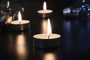 Arka planda elektrik lambası ve mum var. Parlayan lamba ve mum. Elektrik kesintisi yok. Yüksek elektrik fiyatları. Elektrik tasarrufu.