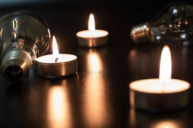 Arka planda elektrik lambası ve mum var. Parlayan lamba ve mum. Elektrik kesintisi yok. Yüksek elektrik fiyatları. Elektrik tasarrufu.