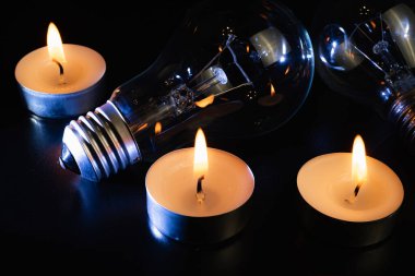 Arka planda elektrik lambası ve mum var. Parlayan lamba ve mum. Elektrik kesintisi yok. Yüksek elektrik fiyatları. Elektrik tasarrufu.