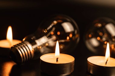 Arka planda elektrik lambası ve mum var. Parlayan lamba ve mum. Elektrik kesintisi yok. Yüksek elektrik fiyatları. Elektrik tasarrufu.