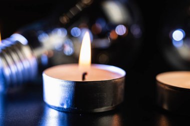 Arka planda elektrik lambası ve mum var. Parlayan lamba ve mum. Elektrik kesintisi yok. Yüksek elektrik fiyatları. Elektrik tasarrufu.