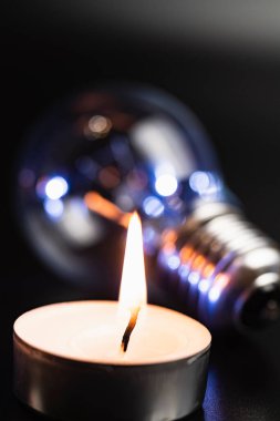 Arka planda elektrik lambası ve mum var. Parlayan lamba ve mum. Elektrik kesintisi yok. Yüksek elektrik fiyatları. Elektrik tasarrufu.