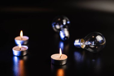 Arka planda elektrik lambası ve mum var. Parlayan lamba ve mum. Elektrik kesintisi yok. Yüksek elektrik fiyatları. Elektrik tasarrufu.