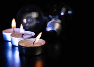 Arka planda elektrik lambası ve mum var. Parlayan lamba ve mum. Elektrik kesintisi yok. Yüksek elektrik fiyatları. Elektrik tasarrufu.