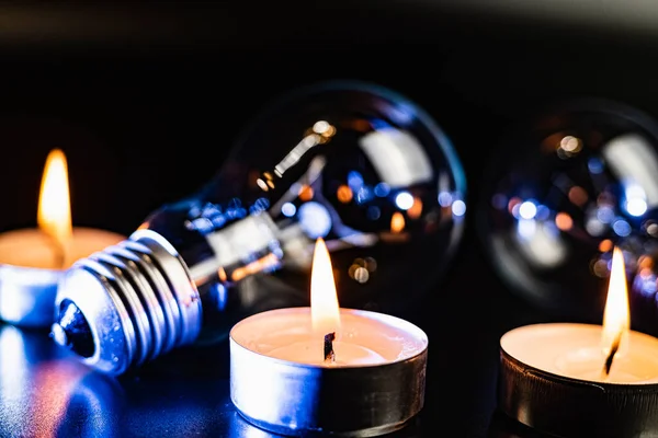 Arka planda elektrik lambası ve mum var. Parlayan lamba ve mum. Elektrik kesintisi yok. Yüksek elektrik fiyatları. Elektrik tasarrufu.