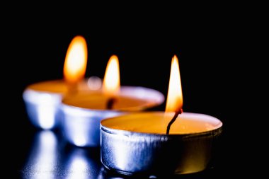 Arka planda yanan bir çok mumun alevi