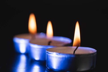 Arka planda yanan bir çok mumun alevi