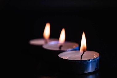 Arka planda yanan bir çok mumun alevi