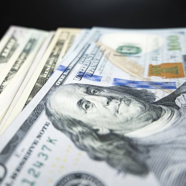 Siyah arka planda 100 dolarlık banknotlar rüşvetin transferi elle yapılır.