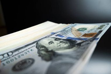 Siyah arka planda 100 dolarlık banknotlar rüşvetin transferi elle yapılır.