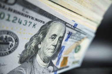 Siyah arka planda 100 dolarlık banknotlar rüşvetin transferi elle yapılır.