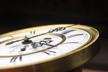 Elleri olan antika bir saat. Altın çerçeveli tarihi bir saatin saat yüzüne yakından bak.