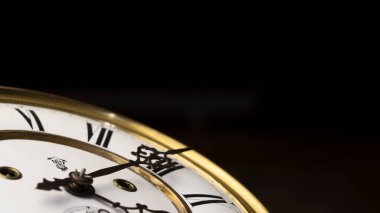 Elleri olan antika bir saat. Altın çerçeveli tarihi bir saatin saat yüzüne yakından bak.