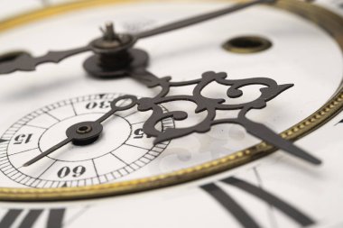 Elleri olan antika bir saat. Altın çerçeveli tarihi bir saatin saat yüzüne yakından bak.