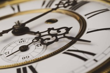 Elleri olan antika bir saat. Altın çerçeveli tarihi bir saatin saat yüzüne yakından bak.