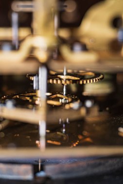 Eski bir saat mekanizması. Tonlama tekniğinde yapılmış bir saat mekanizması. Merkezi dişlilere odaklan. Çok sığ bir alan..