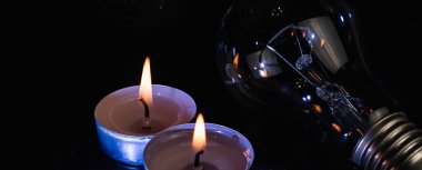 Arka planda elektrik lambası ve mum var. Parlayan lamba ve mum. Elektrik kesintisi yok. Yüksek elektrik fiyatları. Elektrik tasarrufu.