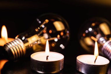 Arka planda elektrik lambası ve mum var. Parlayan lamba ve mum. Elektrik kesintisi yok. Yüksek elektrik fiyatları. Elektrik tasarrufu.