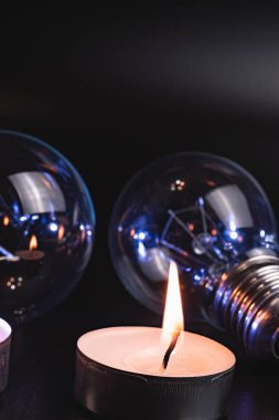 Arka planda elektrik lambası ve mum var. Parlayan lamba ve mum. Elektrik kesintisi yok. Yüksek elektrik fiyatları. Elektrik tasarrufu.