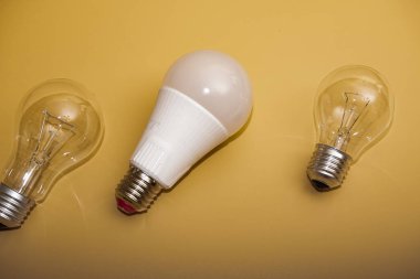 Electric light bulbs. energy efficiency concept. LED lamp vs incandescent lamp. Composition on a yellow background. Use economical light bulbs.