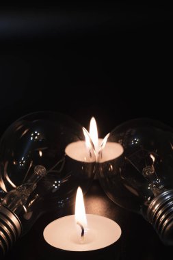 Arka planda elektrik lambası ve mum var. Parlayan lamba ve mum. Elektrik kesintisi yok. Yüksek elektrik fiyatları. Elektrik tasarrufu.