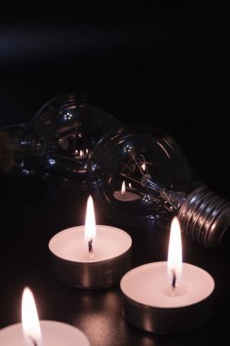 Arka planda elektrik lambası ve mum var. Parlayan lamba ve mum. Elektrik kesintisi yok. Yüksek elektrik fiyatları. Elektrik tasarrufu.