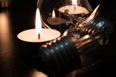 Arka planda elektrik lambası ve mum var. Parlayan lamba ve mum. Elektrik kesintisi yok. Yüksek elektrik fiyatları. Elektrik tasarrufu.