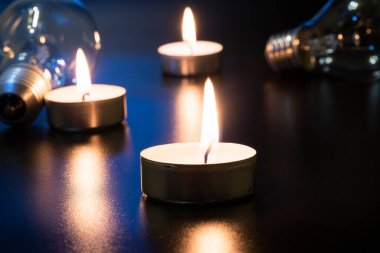 Arka planda elektrik lambası ve mum var. Parlayan lamba ve mum. Elektrik kesintisi yok. Yüksek elektrik fiyatları. Elektrik tasarrufu.