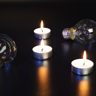Arka planda elektrik lambası ve mum var. Parlayan lamba ve mum. Elektrik kesintisi yok. Yüksek elektrik fiyatları. Elektrik tasarrufu.