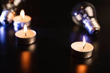 Arka planda elektrik lambası ve mum var. Parlayan lamba ve mum. Elektrik kesintisi yok. Yüksek elektrik fiyatları. Elektrik tasarrufu.