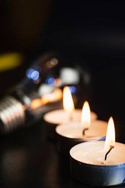 Arka planda elektrik lambası ve mum var. Parlayan lamba ve mum. Elektrik kesintisi yok. Yüksek elektrik fiyatları. Elektrik tasarrufu.