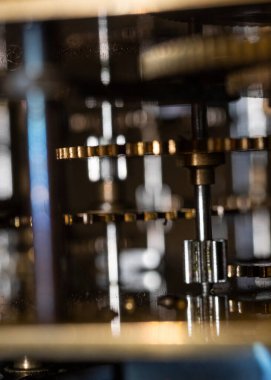 The mechanism of an old watch. clock mechanism made in the technique of toning. Focus on the central gears. Very shallow depth of field