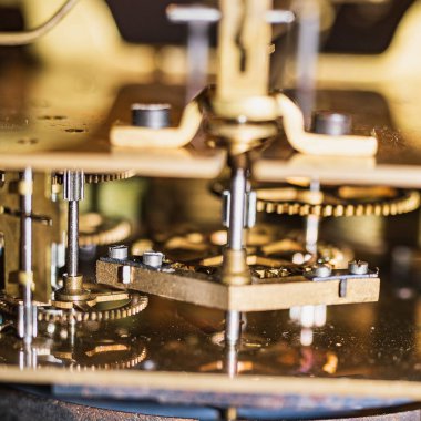 The mechanism of an old watch. clock mechanism made in the technique of toning. Focus on the central gears. Very shallow depth of field