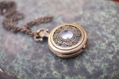 Old vintage books and a watch.Antique pocket watch on opened old book on background.