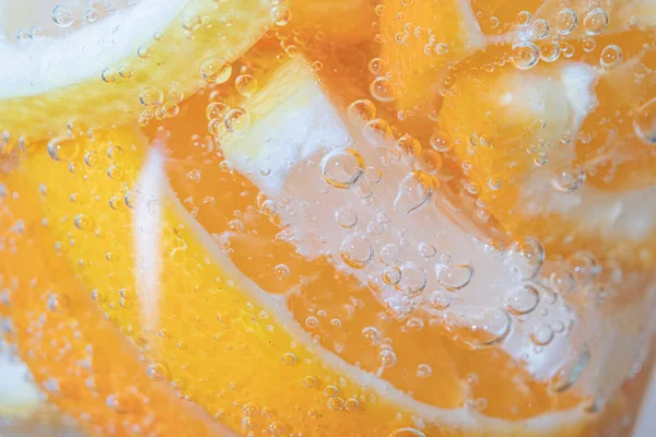 Slices of citrus fruits in sparkling water on white background, closeup.Lemon slices in sparkling mineral water.