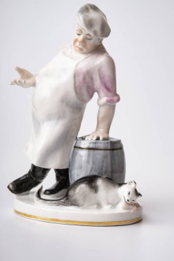 Rare porcelain figurines on a white background. Fat cook and cat eats fish