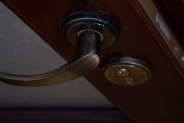a wooden door, a copper door handle or a handle on a wooden door in beautiful lighting