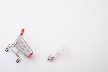 Shopping cart with a light bulb on a white background. the concept of buying light bulbs for the house