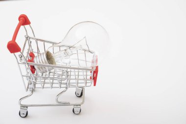 Shopping cart with a light bulb on a white background. the concept of buying light bulbs for the house