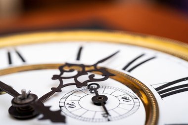 Old wooden clock with a pendulum hanging on the wall